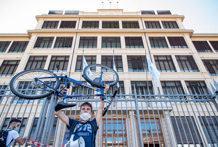 ragazzo che solleva una bicicletta davanti a ex sede Fiat