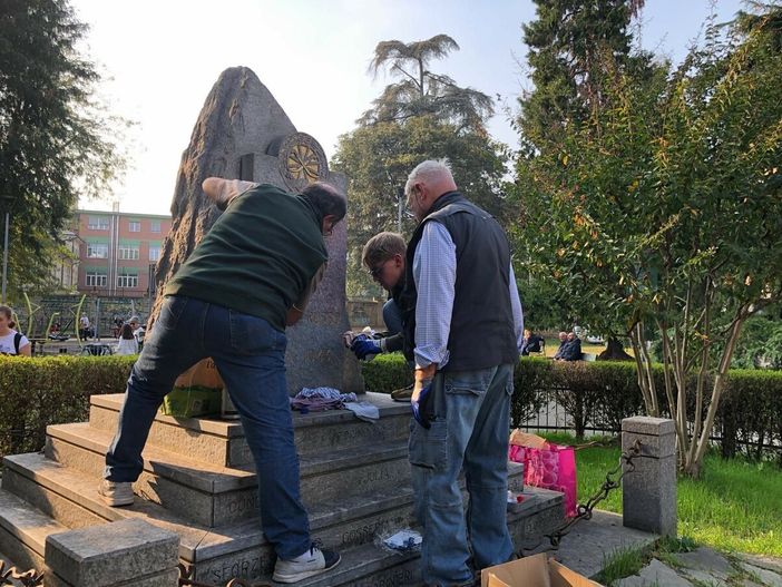Dopo il raid vandalico i volontari rimuovono le scritte dal monumento
