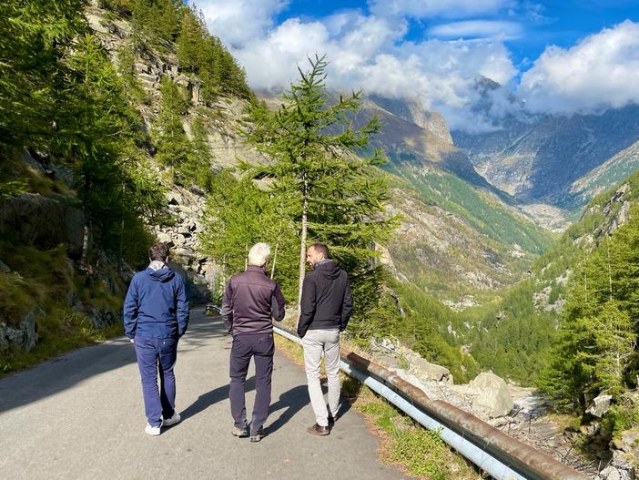 tre persone passeggiano al Parco del Gran Paradiso di spalle tre persone passeggiano al Parco del Gran Paradiso di spalle