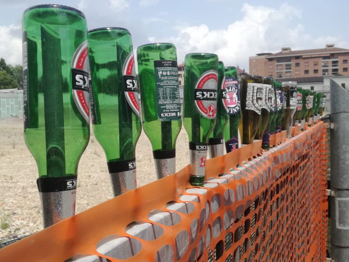 Bottiglie vuote infilate su un cancello