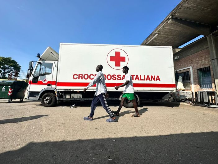 Bus della Croce Rossa e due migranti