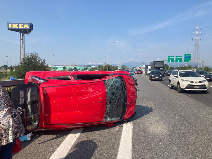 Una vettura ribaltata su un lato dopo uno scontro in tangenziale