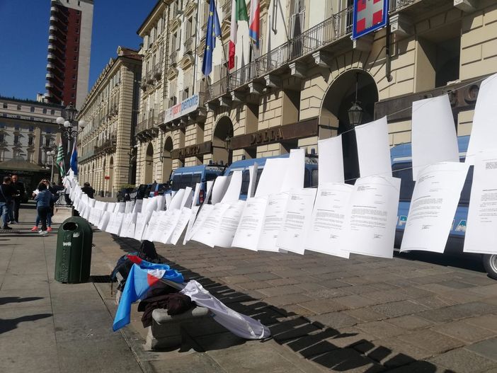 lettere di licenziamento appese a un filo in piazza castello a Torino