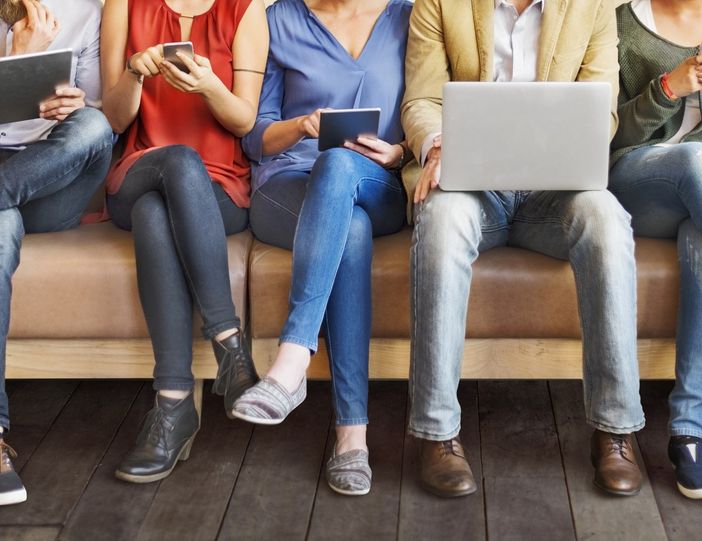 Persone sedute alle prese con dispositivi digitali Persone sedute alle prese con dispositivi digitali