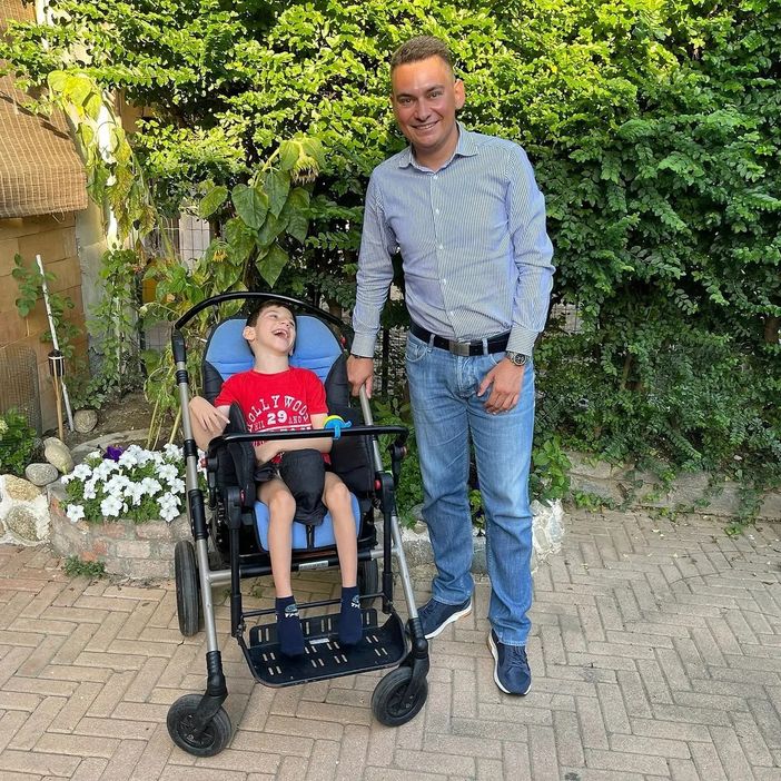 un bimbo e un adulto che lo tiene per mano