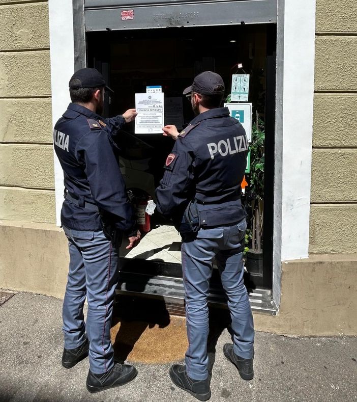 Poliziotti davanti a una saracinesca chiusa