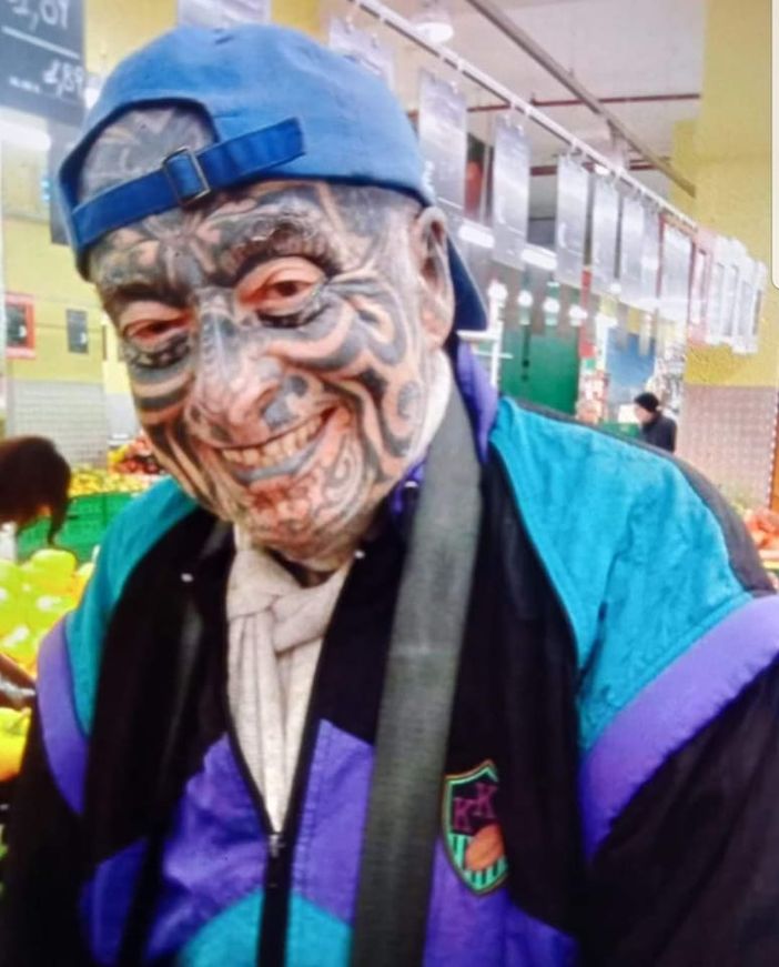 Uomo con molti tatuaggi in faccia che sorride Uomo con molti tatuaggi in faccia che sorride