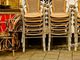Sedie accatastate in ristorante chiuso con bancone vuoto