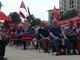 persone sedute con bandiere Cgil