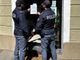 Poliziotti davanti a una saracinesca chiusa