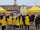 persone vestite di giallo in gruppo davanti a un gazebo