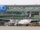 Aeroporto con scritta Torino Airport e un aereo in prima fila