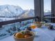 Vista sulla montagna innevata dal Bravo Club di Sestriere, con un tavolo apparecchiato in primo piano