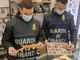 Uomini della Guardia di Finanza con prodotti sequestrati in mano