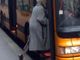 Donna anziana che sale su un bus