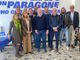 foto di gruppo davanti a simbolo di partito