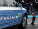 Auto della polizia con agenti in piedi all'esterno