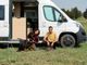 Due persone e un cane davanti a un camper