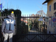 Agente Dia davanti a un cancello di una villa