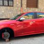 Una Alfa Romeo Mito rossa lasciata su quattro mattoni
