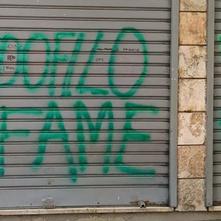 Le scritte sulla serranda del minimarket Le scritte sulla serranda del minimarket