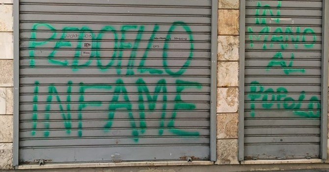 Le scritte sulla serranda del minimarket