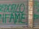 Le scritte sulla serranda del minimarket Le scritte sulla serranda del minimarket