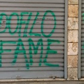 Le scritte sulla serranda del minimarket Le scritte sulla serranda del minimarket