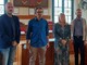 Quattro persone in piedi nella sala del consiglio comunale di Venaria