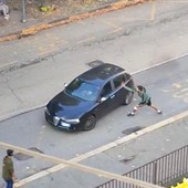 Un ragazzo spacca uno specchietto a un'auto usando un machete