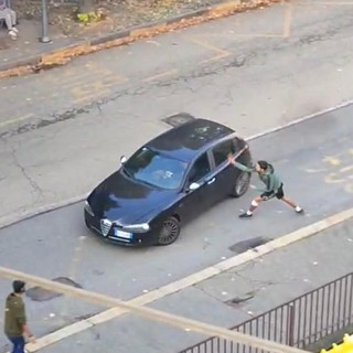 Un ragazzo spacca uno specchietto a un'auto usando un machete