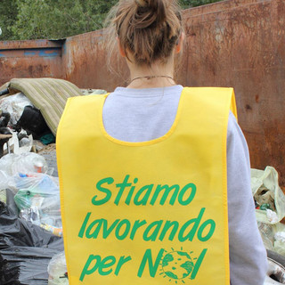 Un volontario di Puliamo il mondo di spalle, con pettorina gialla