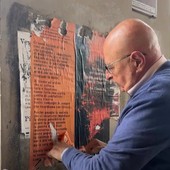 Munito di spruzzino e raschietto: consigliere comunale elimina i manifesti abusivi
