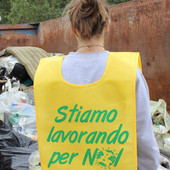 Un volontario di Puliamo il mondo di spalle, con pettorina gialla