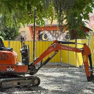 L’escavatore in piazza Muston con dietro il gufo L’escavatore in piazza Muston con dietro il gufo