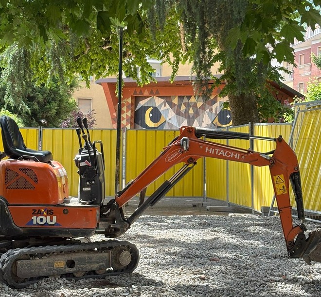 L’escavatore in piazza Muston con dietro il gufo L’escavatore in piazza Muston con dietro il gufo