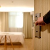 Persona che apre una porta di camera d'albergo