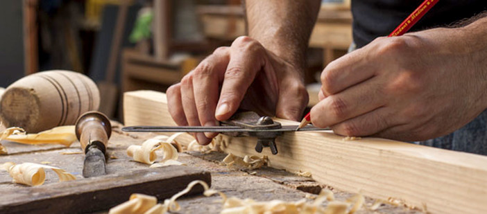 Artigiano al lavoro con mano che lavora il legno