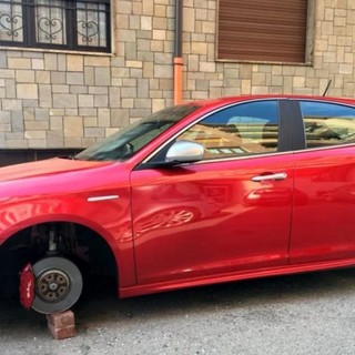 Una Alfa Romeo Mito rossa lasciata su quattro mattoni