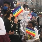 ragazzi e manifestanti che chiedono pace con bandiere arcobaleno