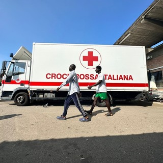 Bus della Croce Rossa e due migranti