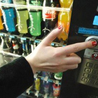distributore automatico con mano che seleziona prodotto