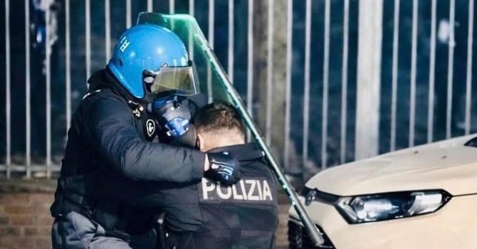 L'agente soccorso da un  collega dopo essere stato accerchiato e picchiato