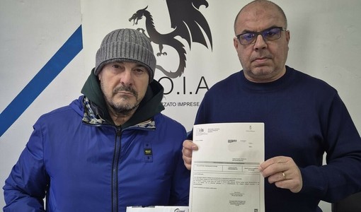 Giancarlo Nardozzi con il negoziante di Barriera e i bollettini da pagare