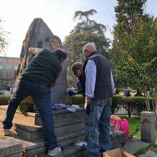 Dopo il raid vandalico i volontari rimuovono le scritte dal monumento