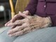 mani di una donna anziana seduta