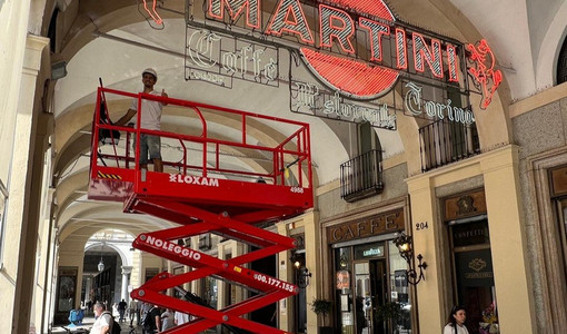 Operai al lavoro per pulire le storiche insegne del Caffè Torino Operai al lavoro per pulire le storiche insegne del Caffè Torino