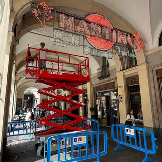 Operai al lavoro per pulire le storiche insegne del Caffè Torino Operai al lavoro per pulire le storiche insegne del Caffè Torino