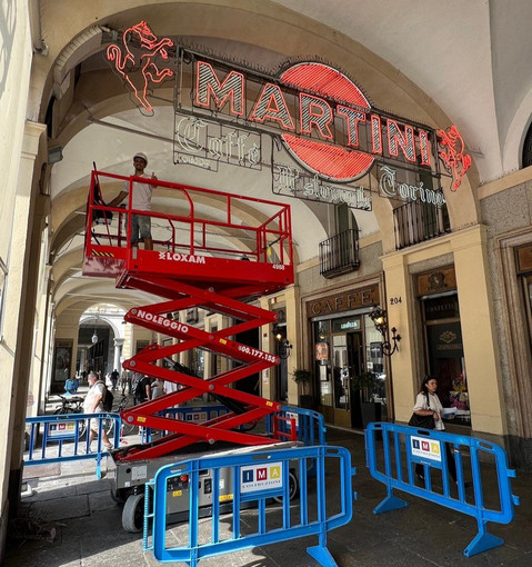 Operai al lavoro per pulire le storiche insegne del Caffè Torino Operai al lavoro per pulire le storiche insegne del Caffè Torino