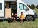 Due persone e un cane davanti a un camper
